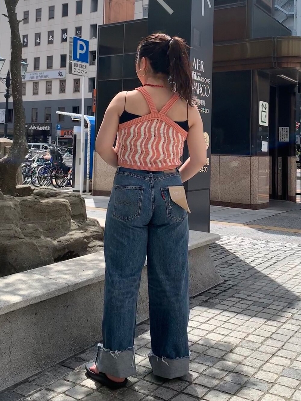 ブルー系のデニムパンツ、ピンク系のキャミソールを着用したレディースの春コーディネートの3枚目の写真