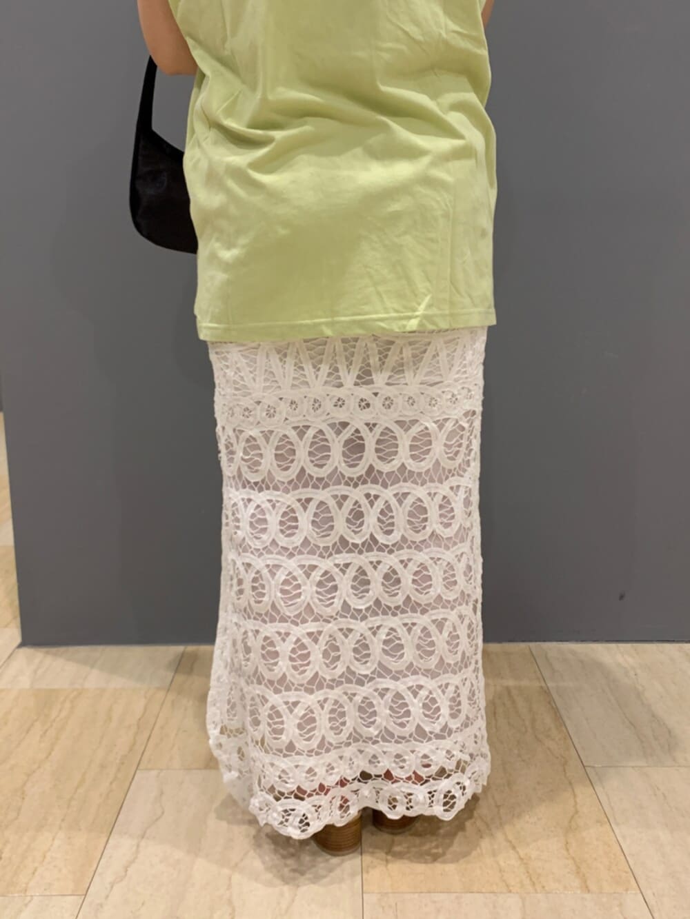 グリーン系のタンクトップ、ホワイト系のスカートを着用したレディースの夏コーディネートの7枚目の写真