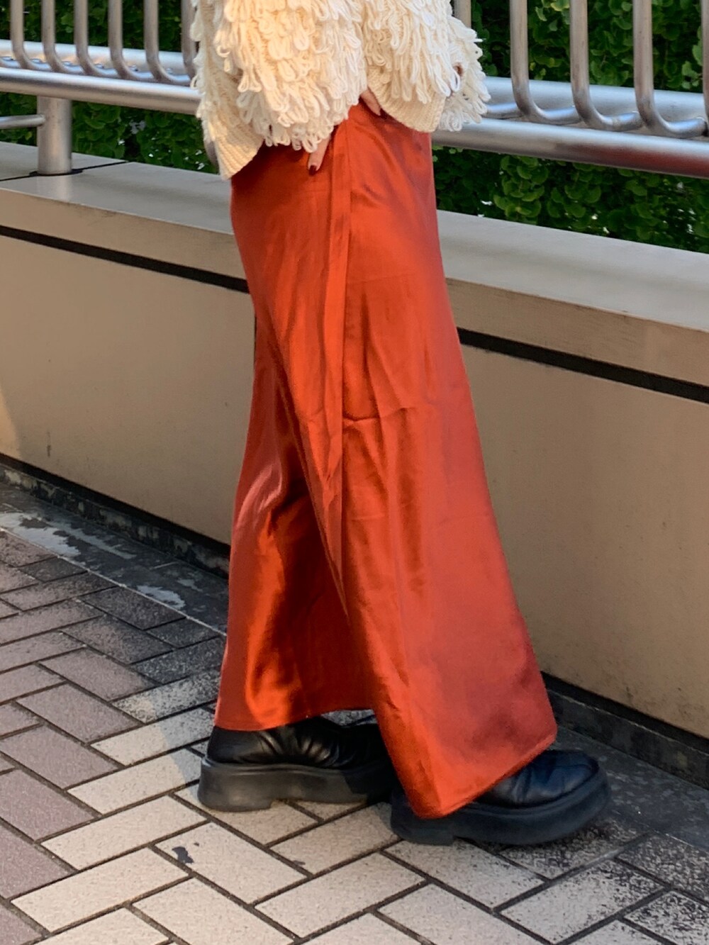 ホワイト系のカーディガン/ボレロ、ホワイト系のTシャツ/カットソー、オレンジ系のスカートを着用したレディースの冬コーディネートの6枚目の写真