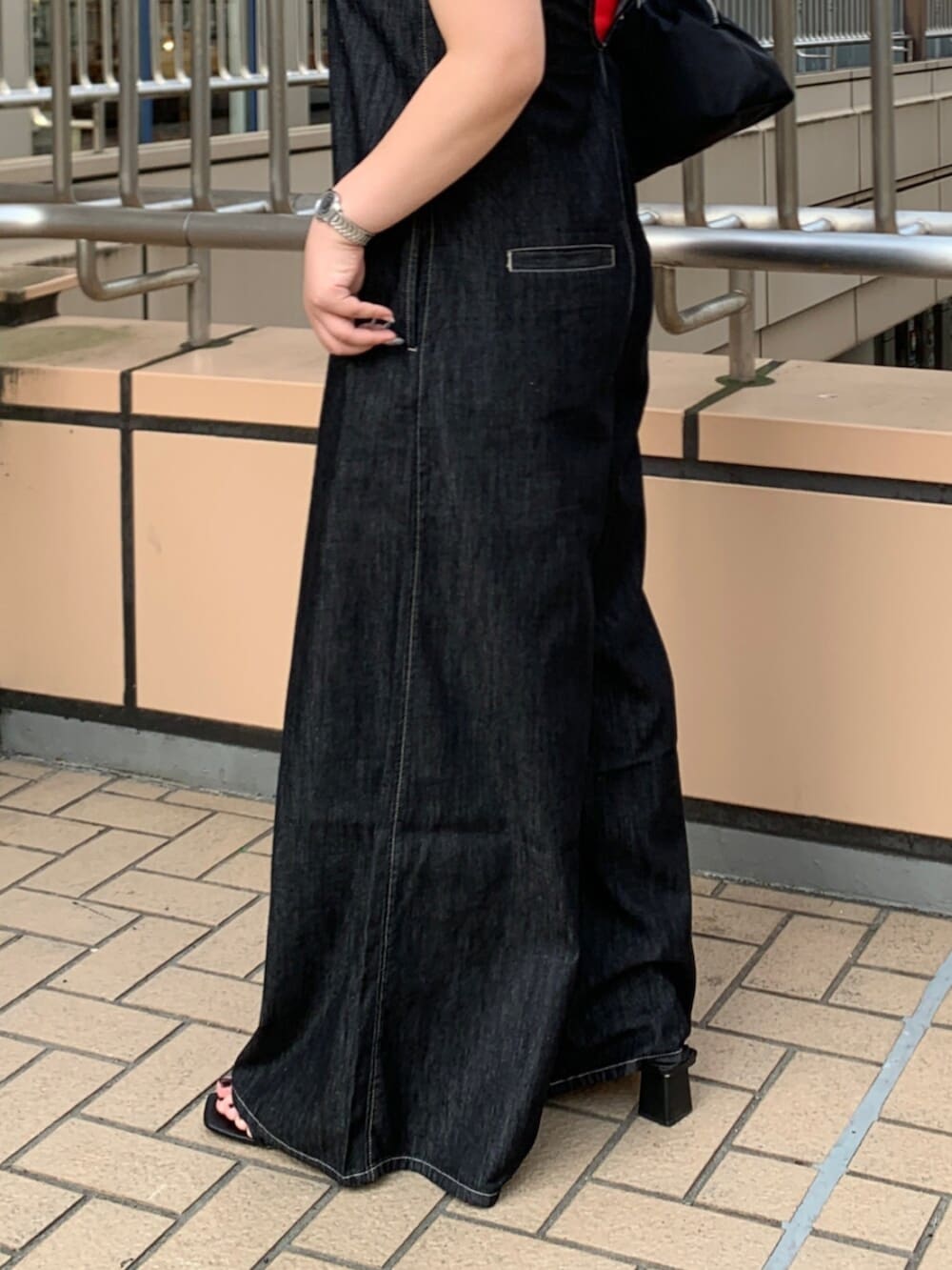 ブラック系のつなぎ/オールインワン、レッド系のキャミソールを着用したレディースの夏コーディネートの6枚目の写真