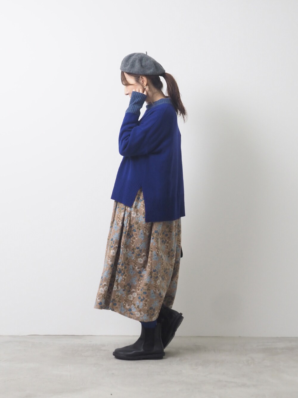 パープル系のニット/セーター、ブラック系のショルダーバッグ、ブラック系のブーツを着用したレディースの秋コーディネートの2枚目の写真