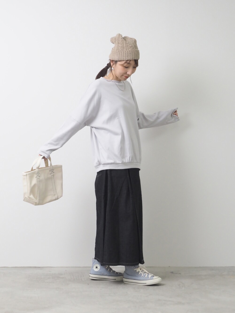 ブルー系のTシャツ/カットソー、ブラック系のデニムスカート、ホワイト系のトートバッグを着用したレディースの夏コーディネートの2枚目の写真