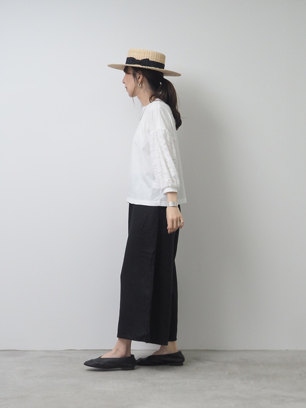 ホワイト系のTシャツ/カットソー、ブラック系のパンツを着用したレディースの夏コーディネートの2枚目の写真
