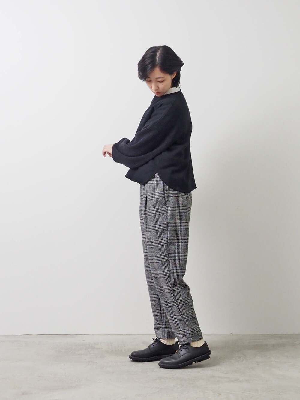 ブラック系のTシャツ/カットソー、グレー系のパンツを着用したレディースの冬コーディネートの2枚目の写真