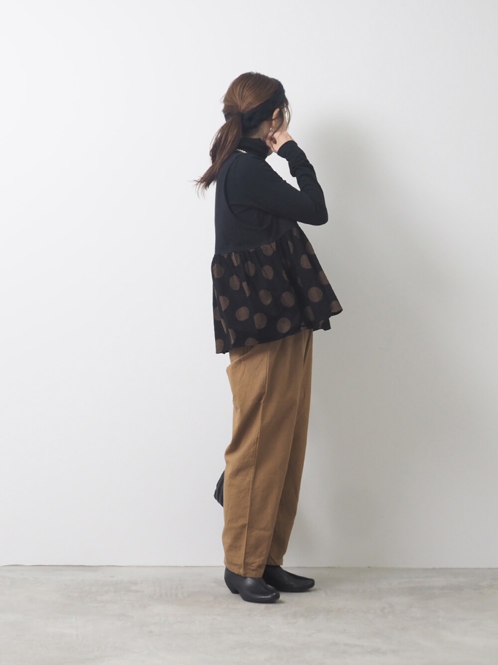 ベージュ系のベスト、ベージュ系のパンツを着用したレディースの秋コーディネートの2枚目の写真