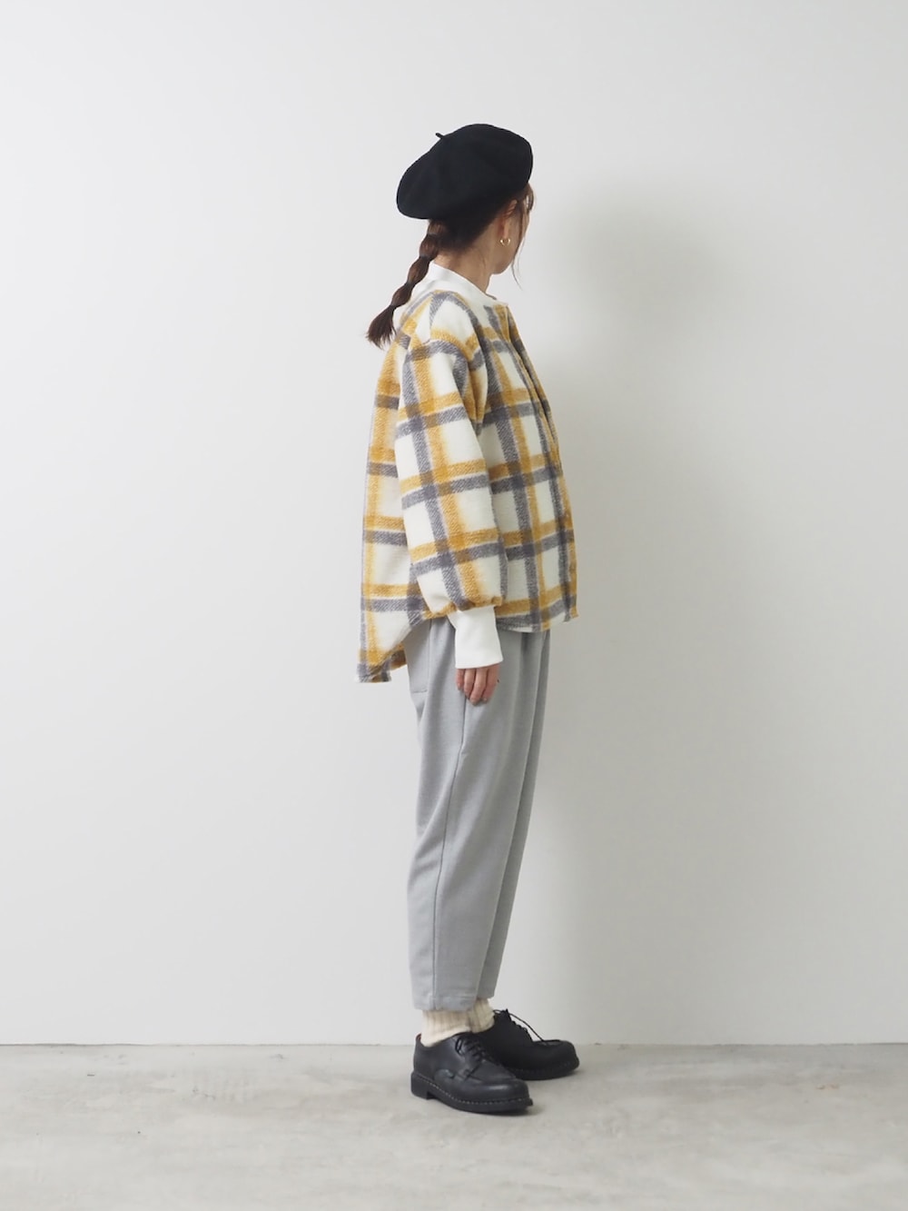 イエロー系のノーカラージャケット、グレー系のパンツを着用したレディースの秋コーディネートの2枚目の写真