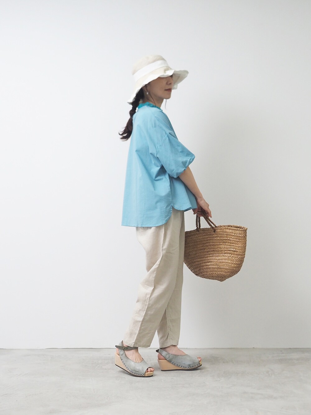 ブルー系のシャツ/ブラウス、ベージュ系のパンツ、ブルー系のサンダルを着用したレディースの夏コーディネートの2枚目の写真