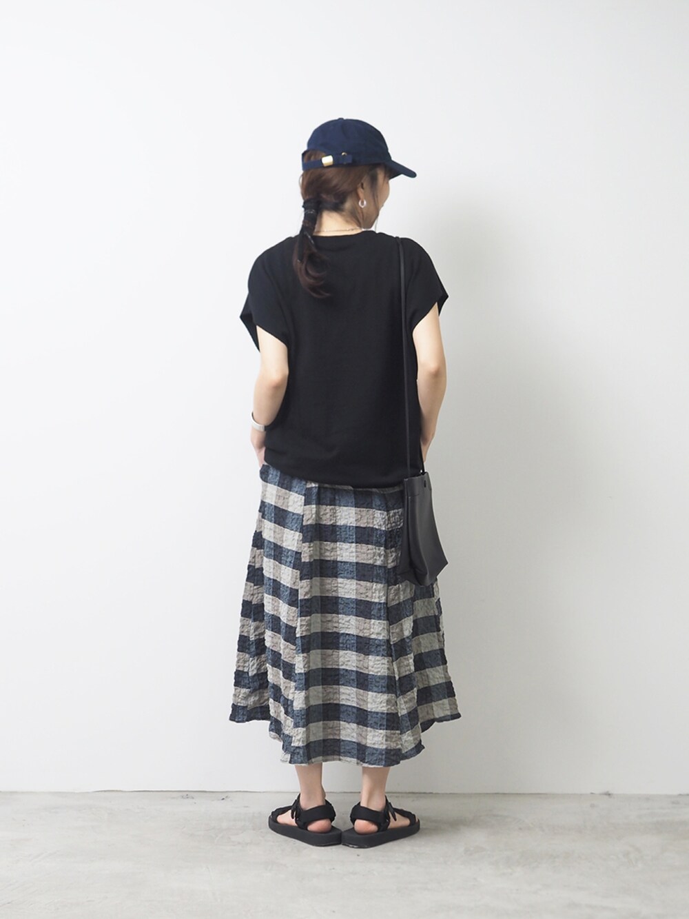 ベージュ系のスカート、ブラック系のTシャツ/カットソーを着用したレディースの夏コーディネートの2枚目の写真