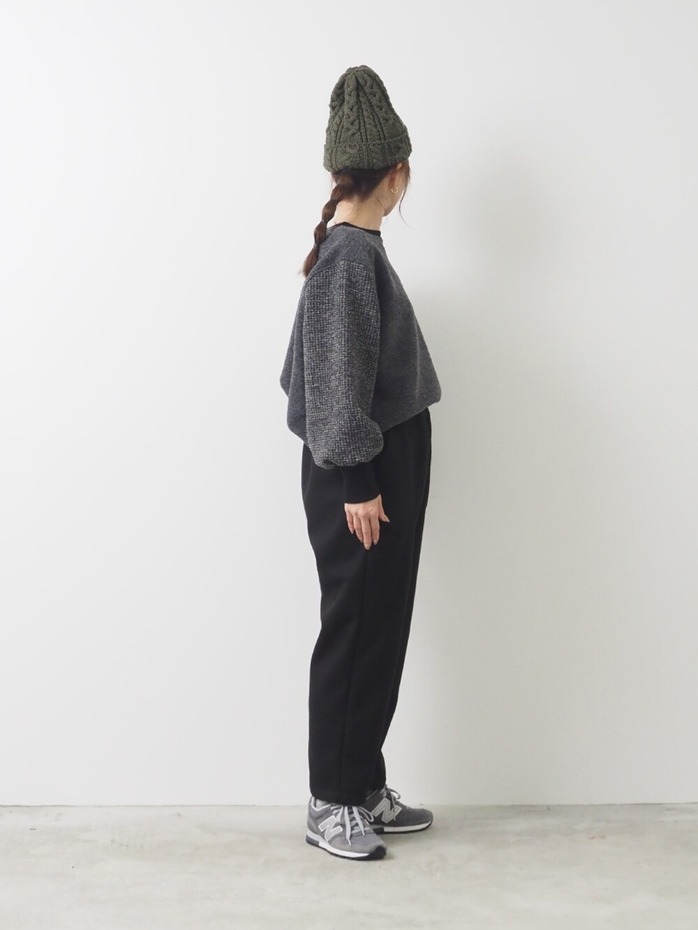 グレー系のトップス、ブラック系のパンツを着用したレディースの秋コーディネートの2枚目の写真