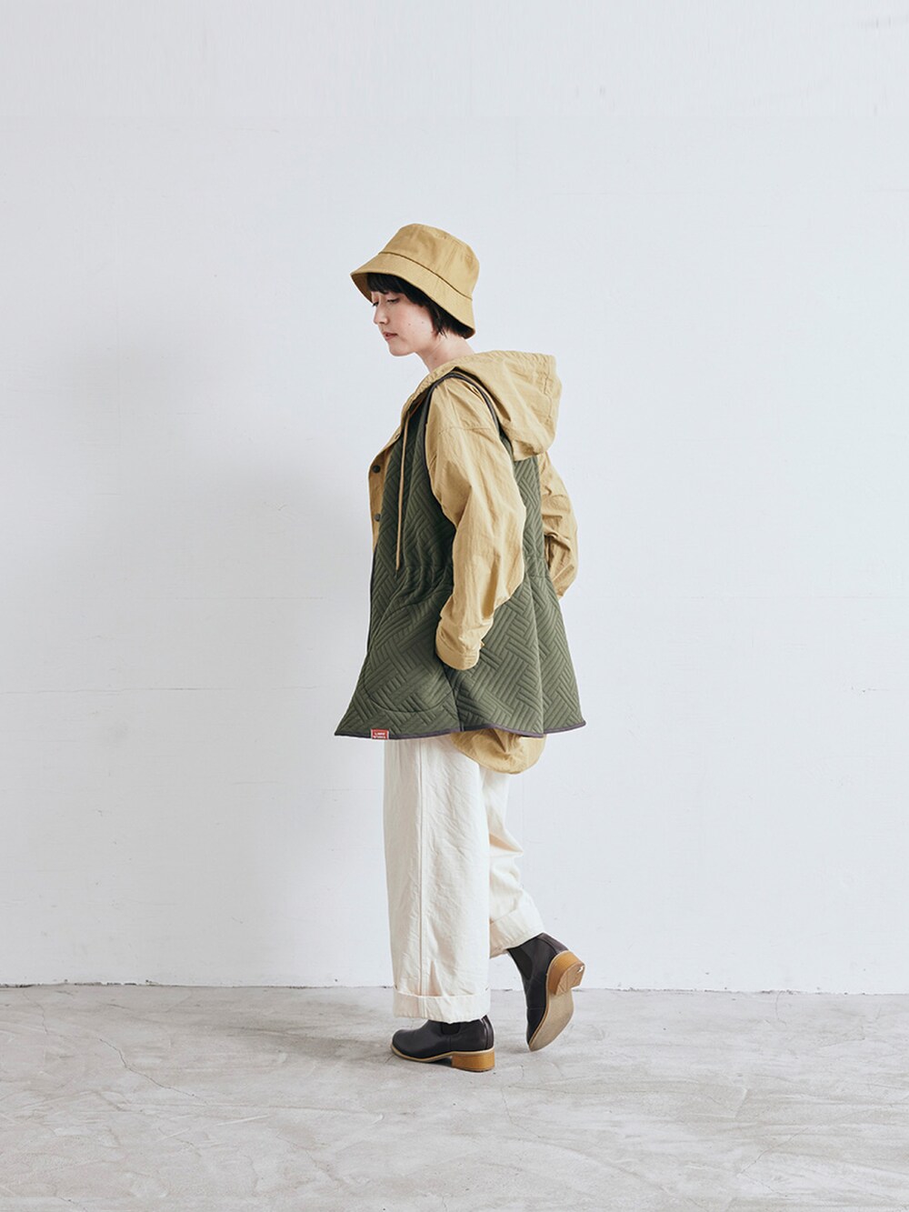 ベージュ系のナイロンジャケット、ホワイト系のデニムパンツを着用したレディースの冬コーディネートの2枚目の写真