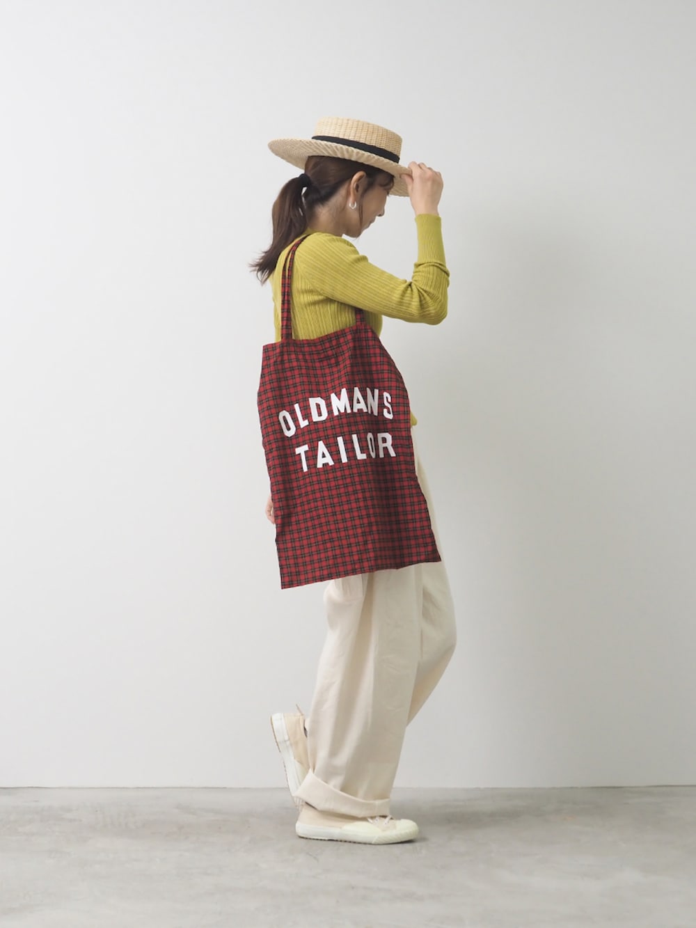 グリーン系のニット/セーター、ホワイト系のパンツを着用したレディースの夏コーディネートの2枚目の写真