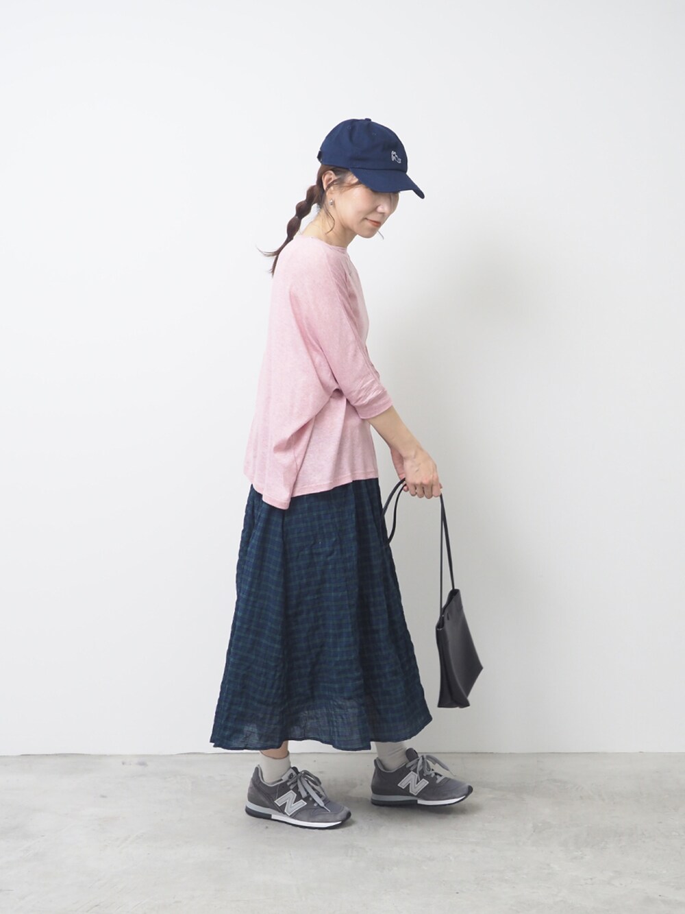 ピンク系のTシャツ/カットソー、ホワイト系のスカート、グレー系のスニーカーを着用したレディースの夏コーディネートの2枚目の写真