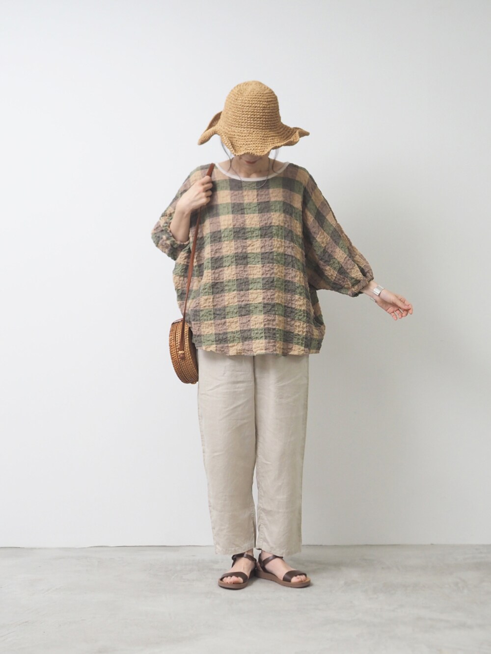 ブラック系のシャツ/ブラウス、ベージュ系のパンツを着用したレディースの夏コーディネートの2枚目の写真