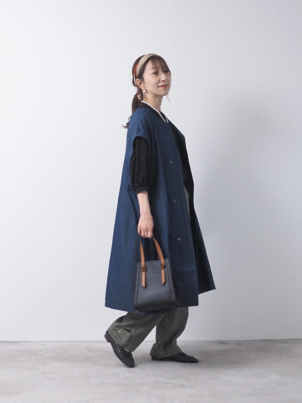 ブルー系のデニムジャケット、グリーン系のパンツを着用したレディースの夏コーディネートの2枚目の写真