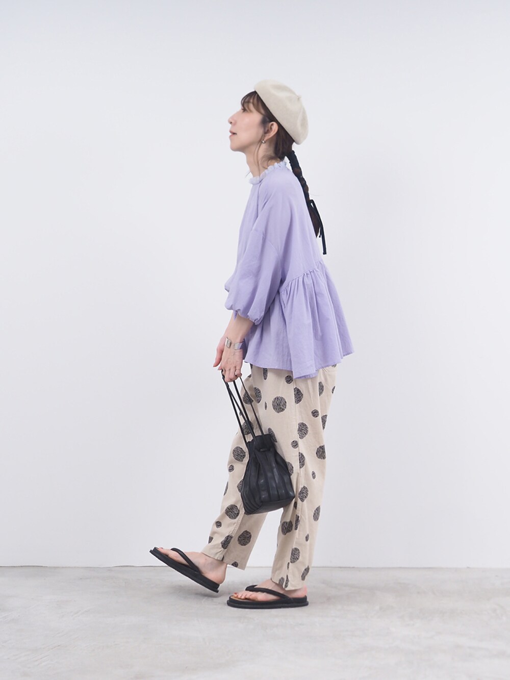パープル系のシャツ/ブラウス、ベージュ系のパンツを着用したレディースの夏コーディネートの2枚目の写真