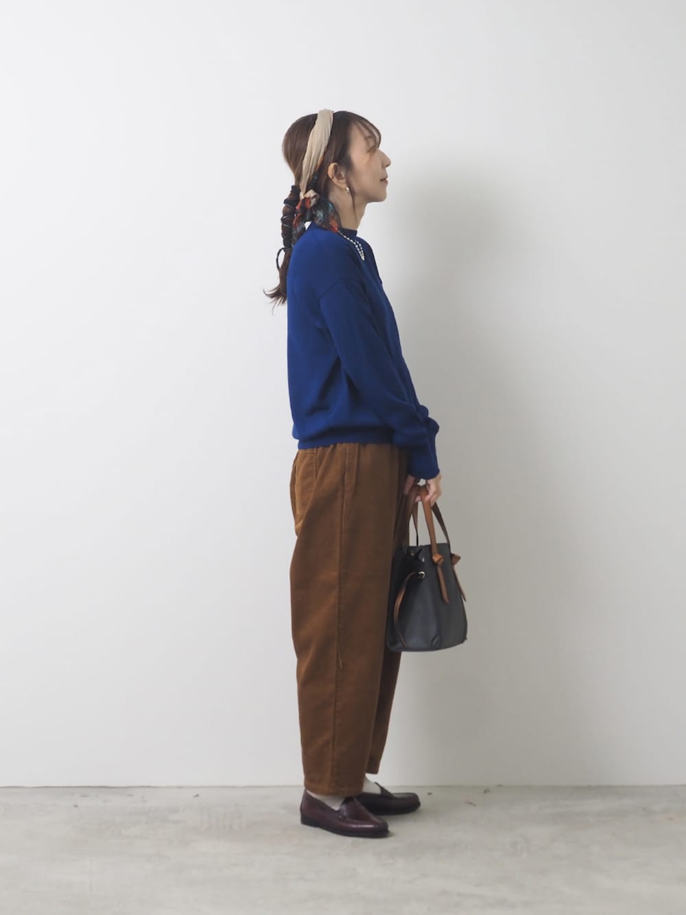 ブルー系のTシャツ/カットソー、ブラウン系のパンツを着用したレディースの秋コーディネートの2枚目の写真