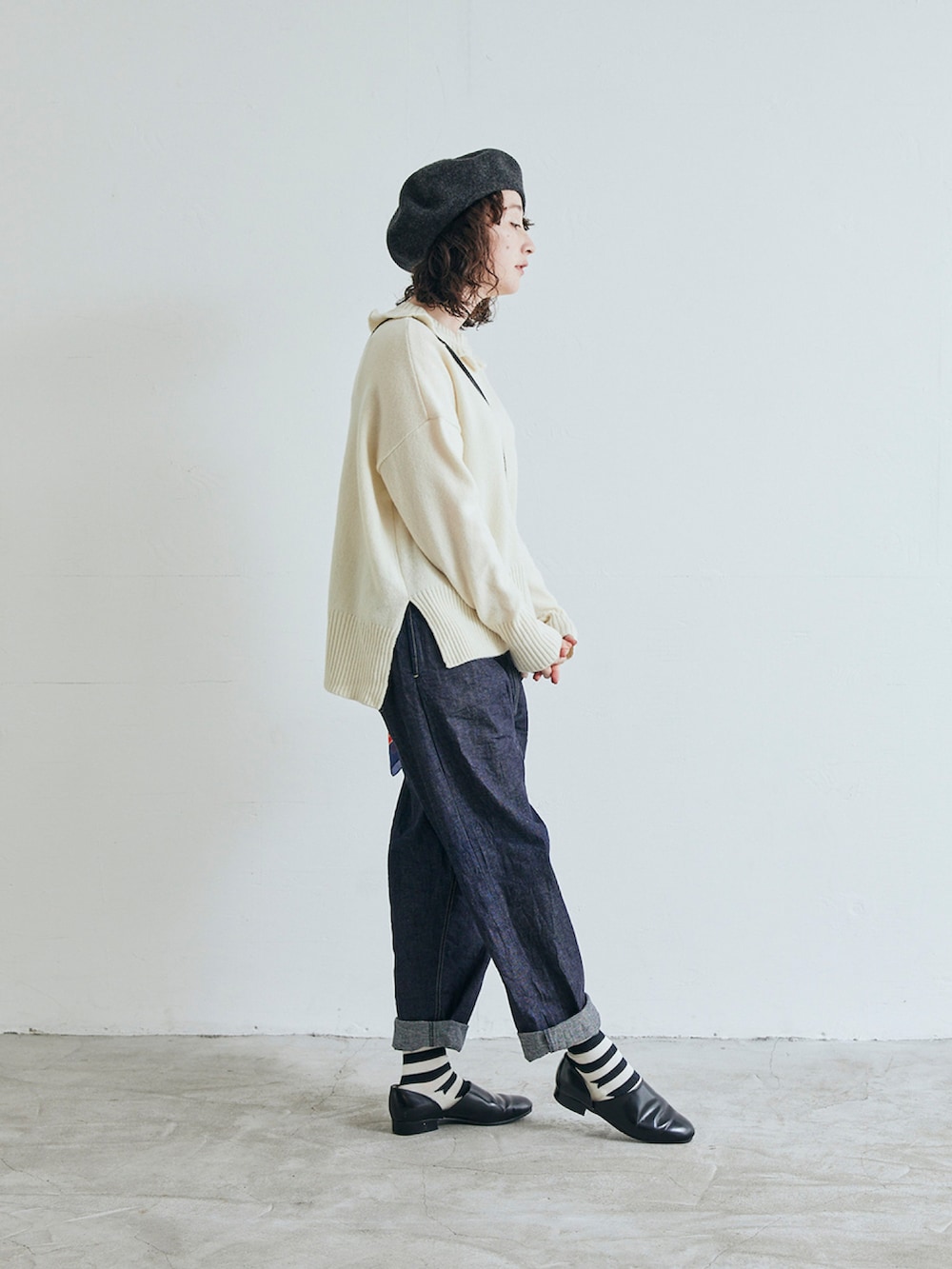 ホワイト系のニット/セーター、ブルー系のデニムパンツを着用したレディースの秋コーディネートの2枚目の写真