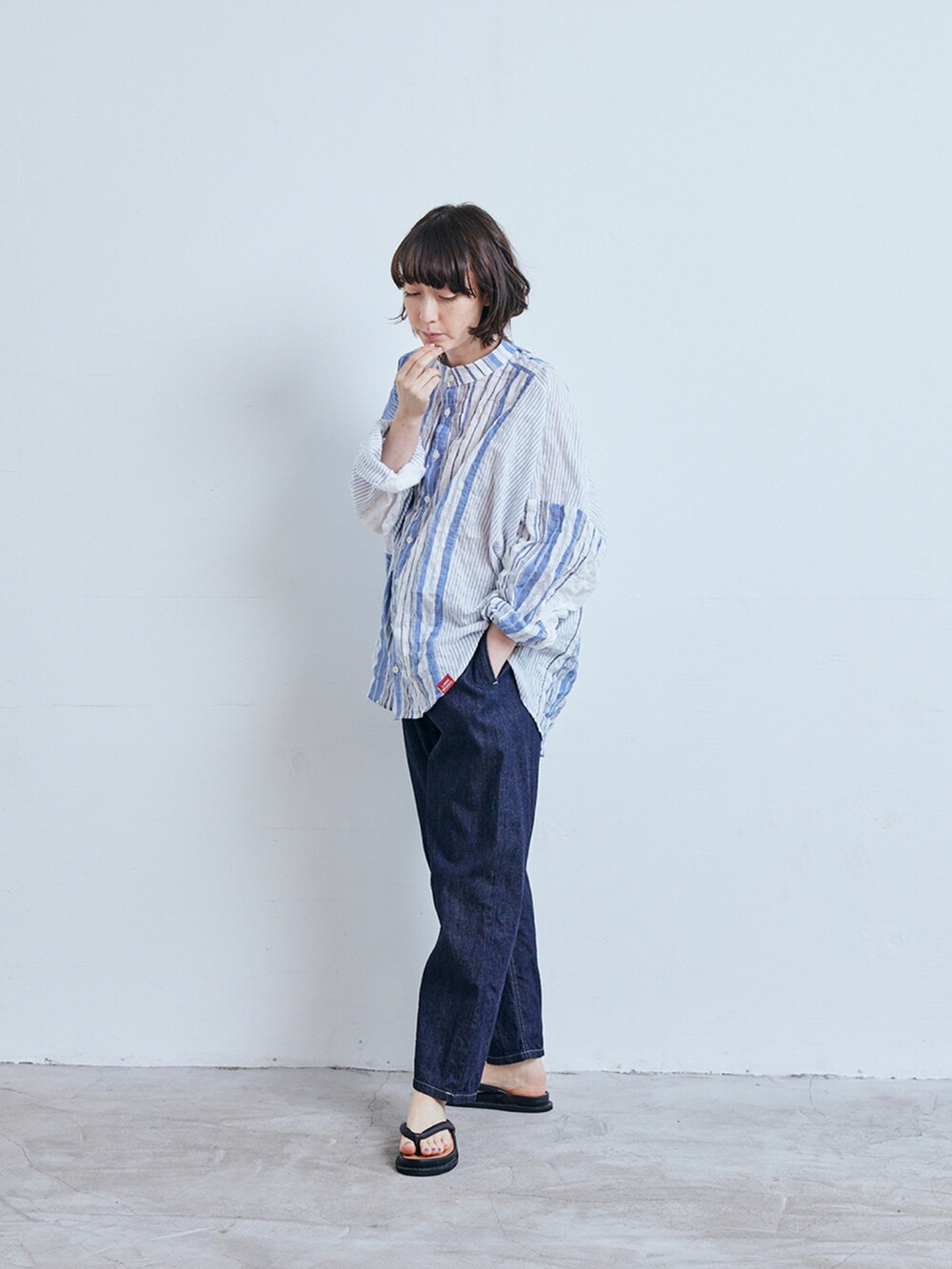 ブルー系のシャツ/ブラウス、ブルー系のデニムパンツ、ブラック系のサンダルを着用したレディースの春コーディネートの2枚目の写真