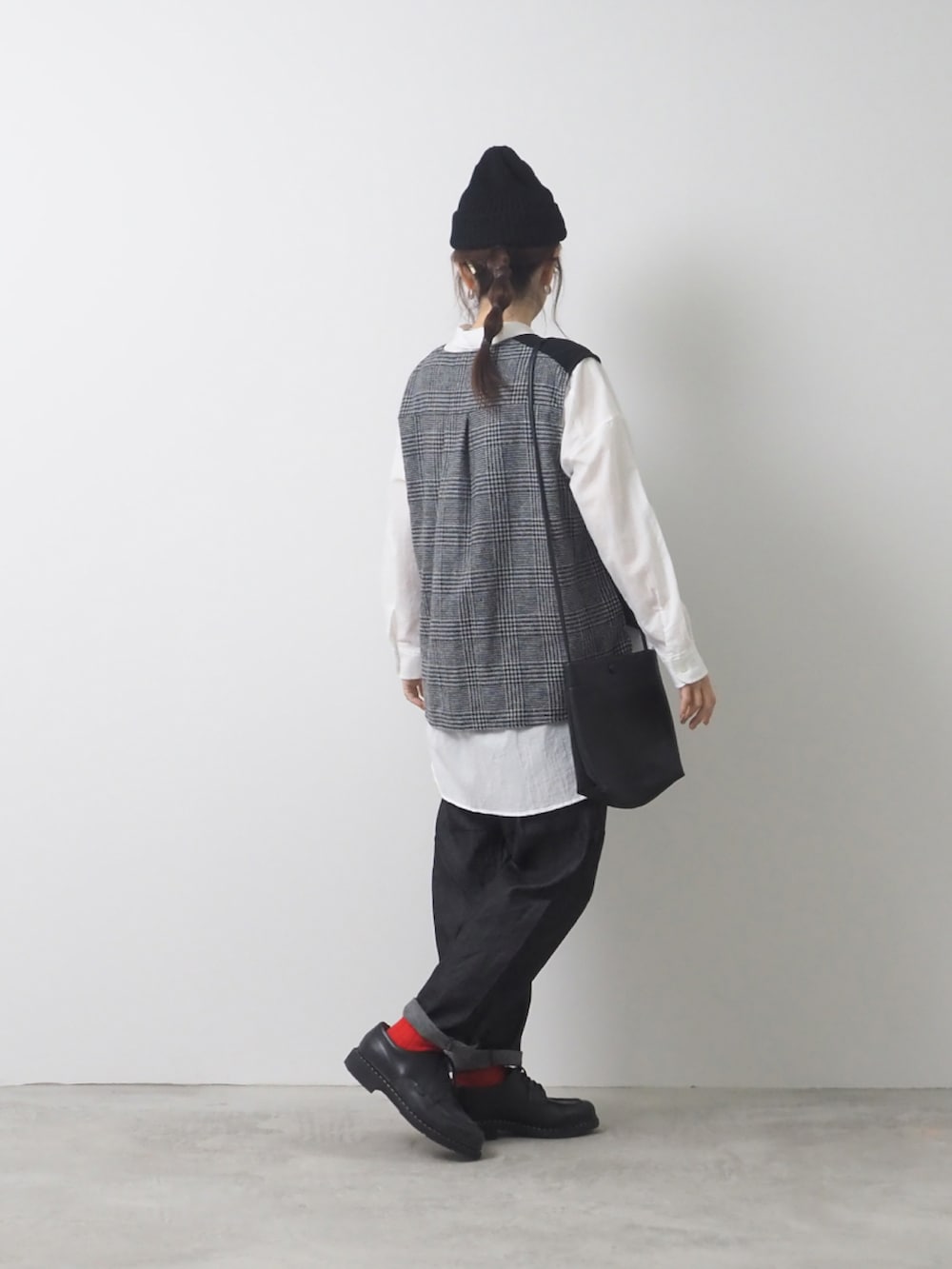 ベージュ系のベスト、ブラック系のデニムパンツを着用したレディースの秋コーディネートの2枚目の写真