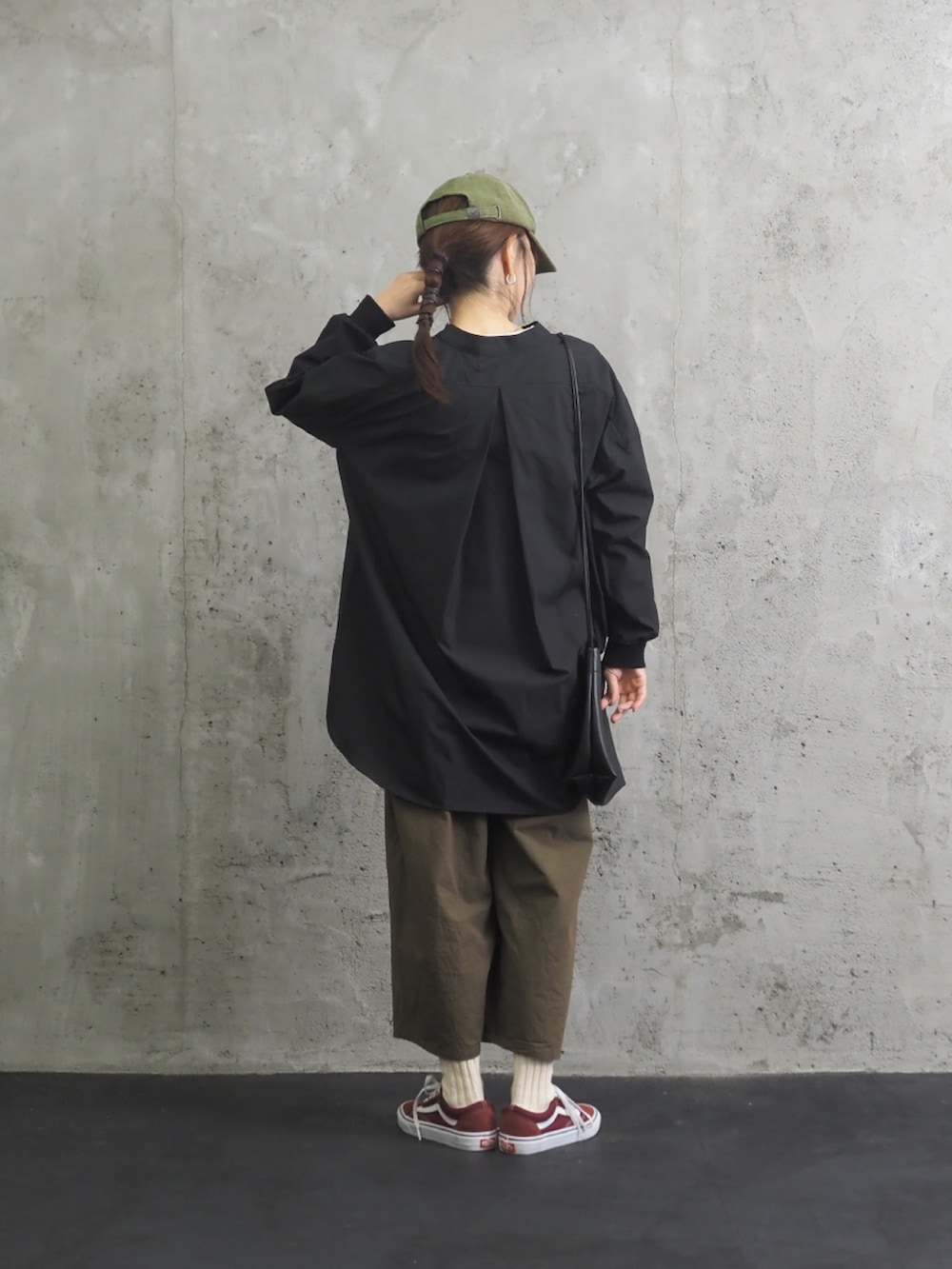 ブラック系のシャツ/ブラウス、グリーン系のパンツ、レッド系のスニーカーを着用したレディースの秋コーディネートの2枚目の写真