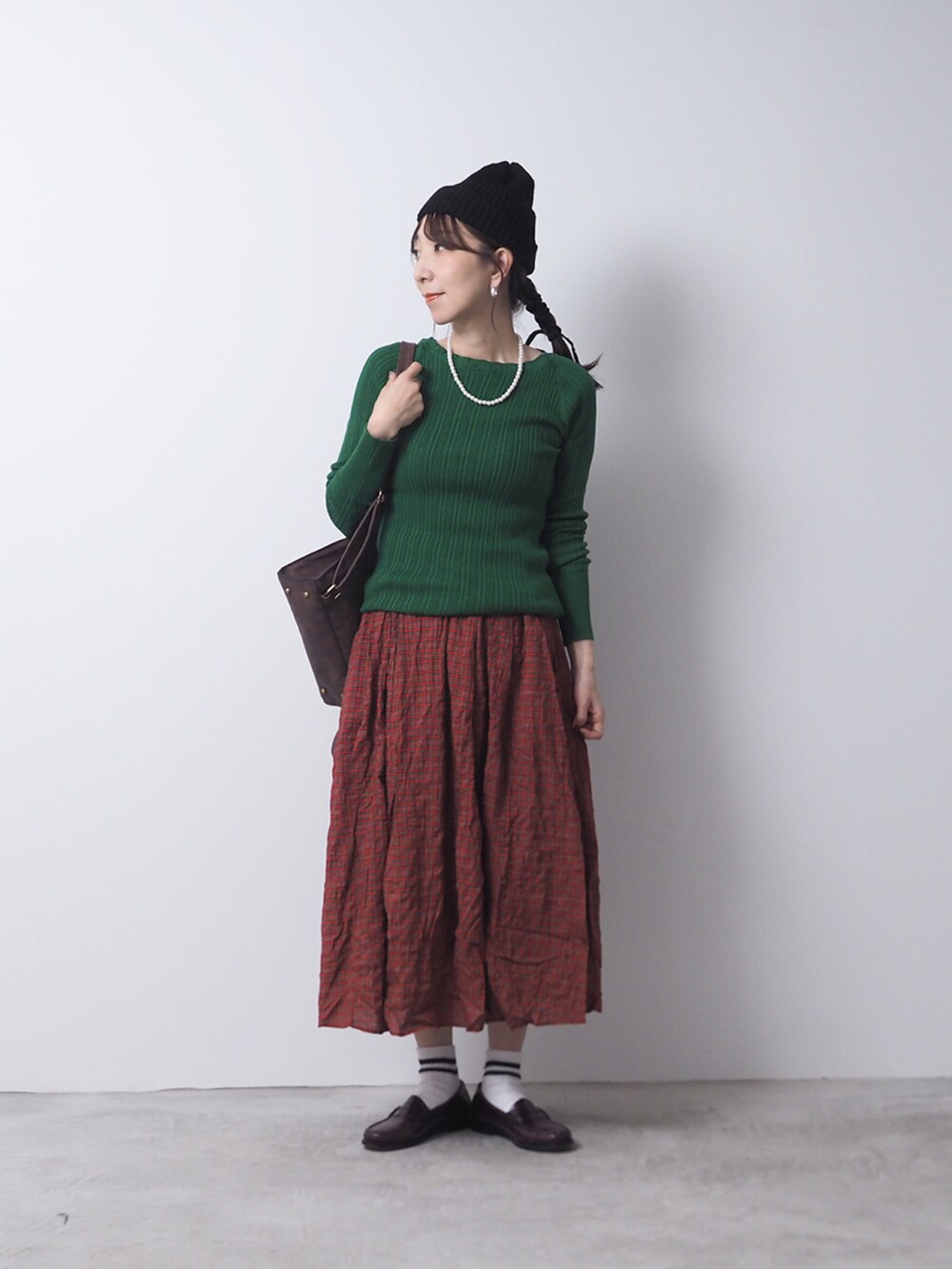 グリーン系のニット/セーター、ブルー系のスカートを着用したレディースの夏コーディネートの2枚目の写真