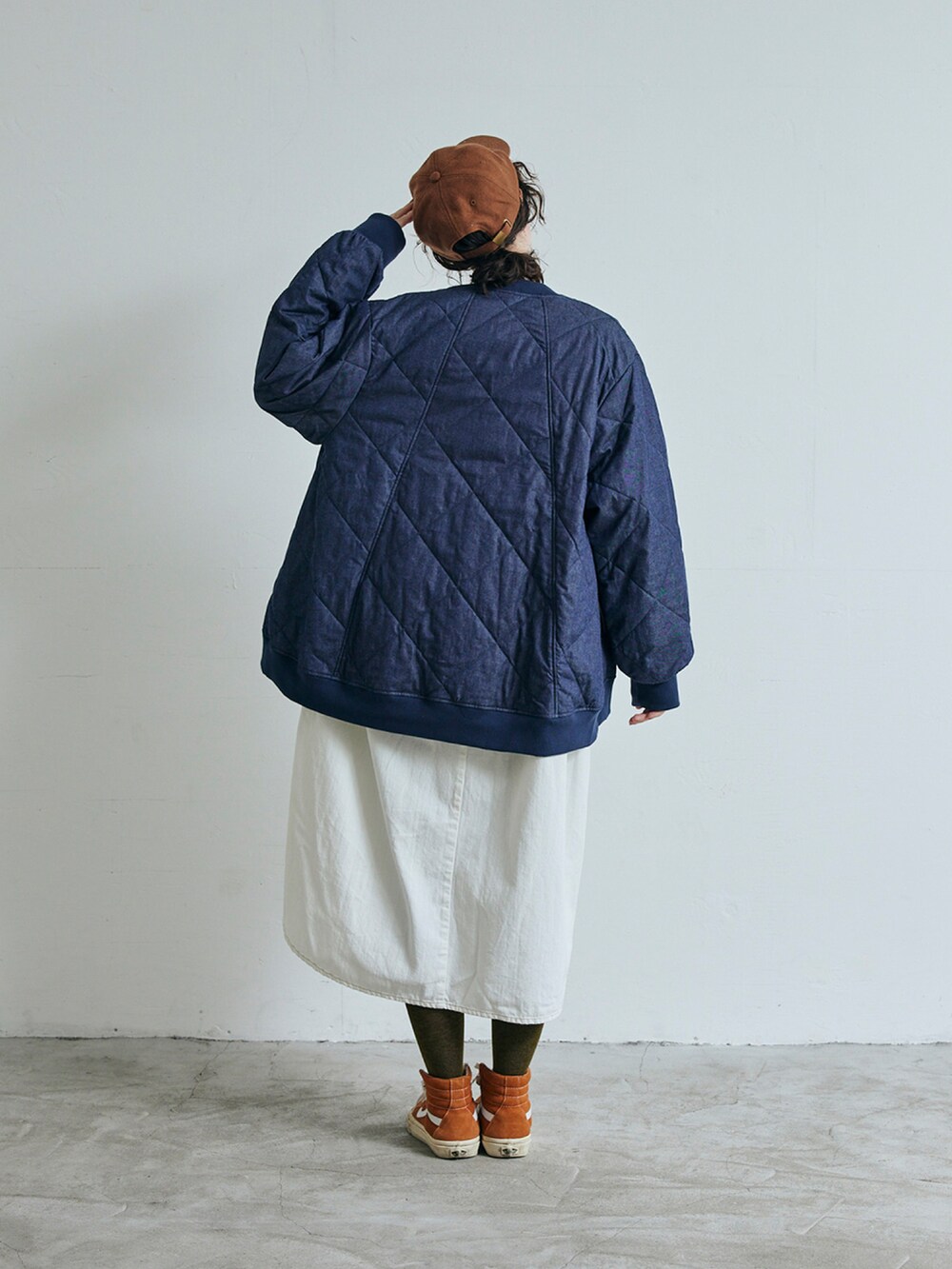 ブルー系のデニムジャケット、ホワイト系のワンピースを着用したレディースの秋コーディネートの2枚目の写真