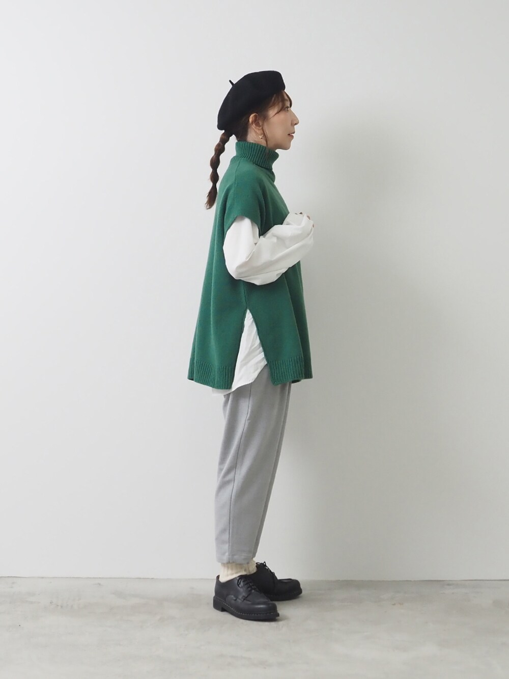 グリーン系のベスト、グレー系のパンツを着用したレディースの秋コーディネートの2枚目の写真