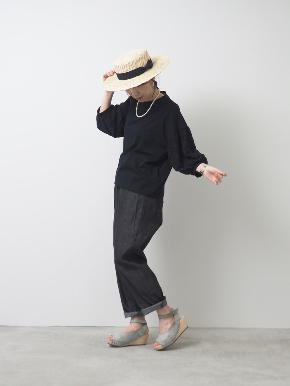 ブラック系のTシャツ/カットソー、ブラック系のデニムパンツ、ブルー系のサンダルを着用したレディースの夏コーディネートの2枚目の写真