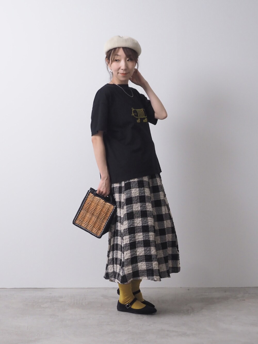 ホワイト系のTシャツ/カットソー、ベージュ系のスカート、ブラック系のショルダーバッグを着用したレディースの夏コーディネートの2枚目の写真
