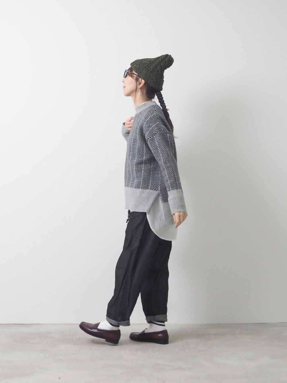 グレー系のニット/セーター、ブラック系のデニムパンツを着用したレディースの秋コーディネートの2枚目の写真