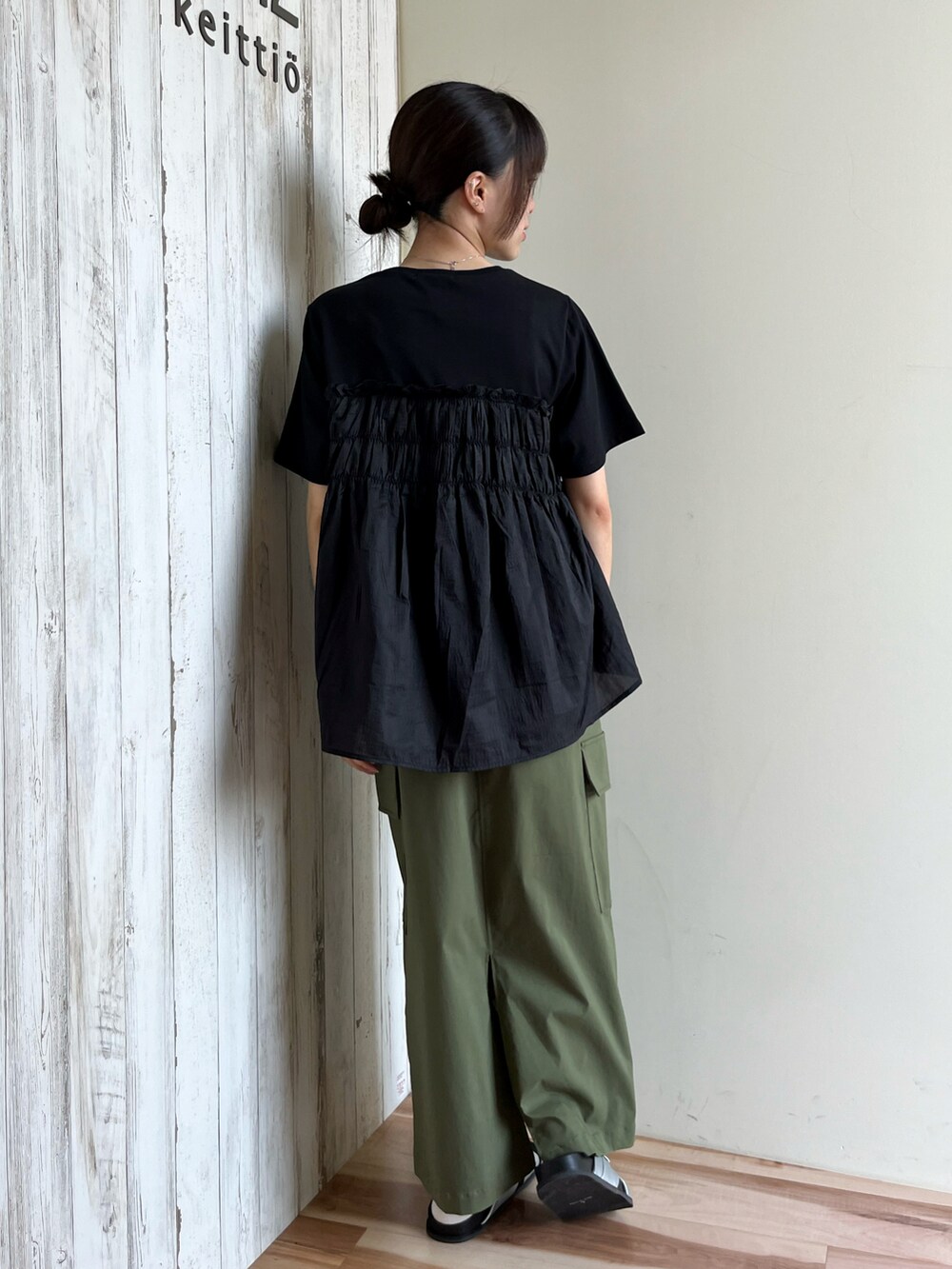 ブラック系のTシャツ/カットソー、グリーン系のスカート、シルバー系のドレスシューズを着用したレディースの夏コーディネートの2枚目の写真