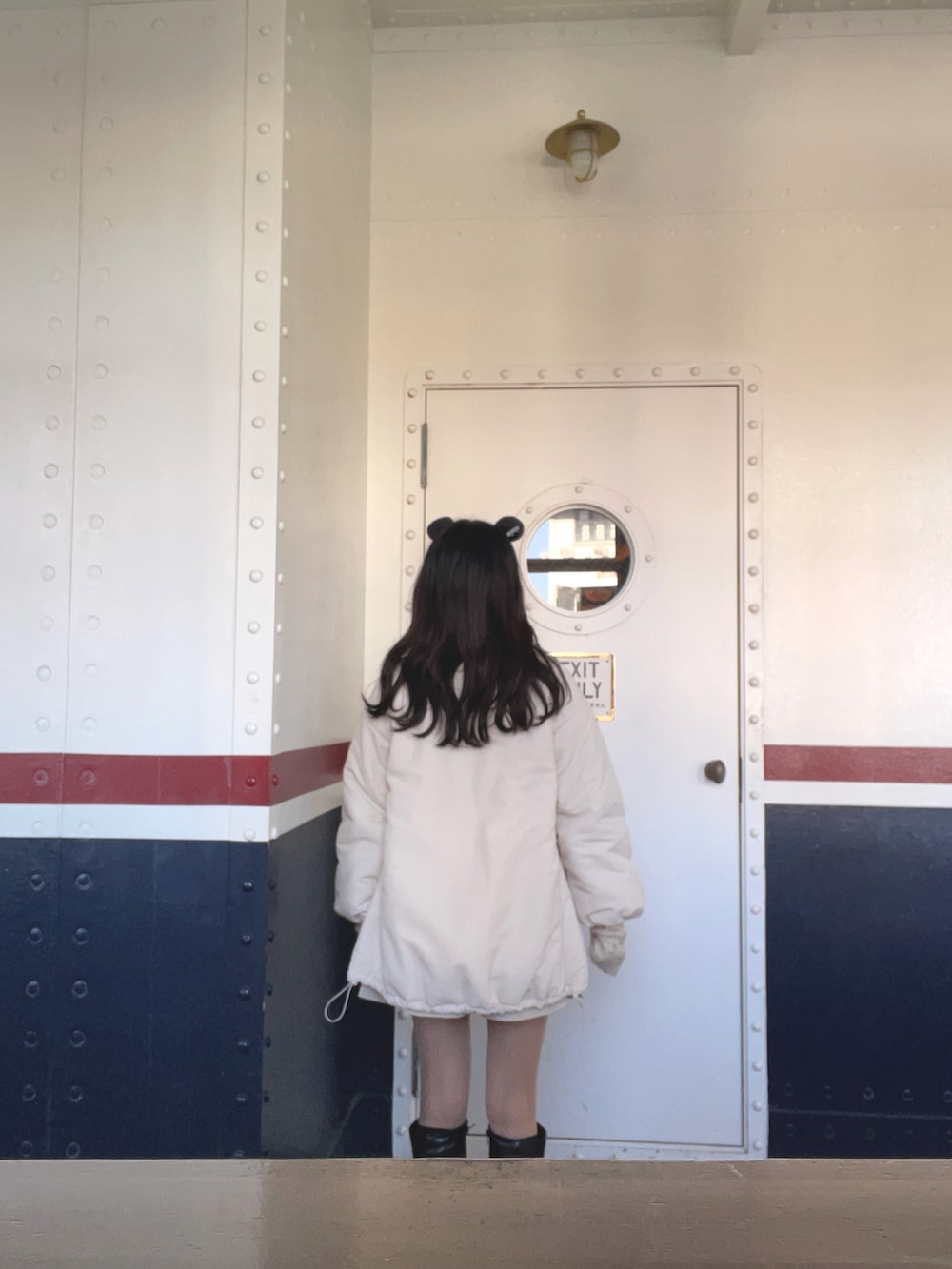 ホワイト系のブルゾン、ベージュ系のニット/セーター、ブラック系のブーツを着用したレディースの春コーディネートの3枚目の写真