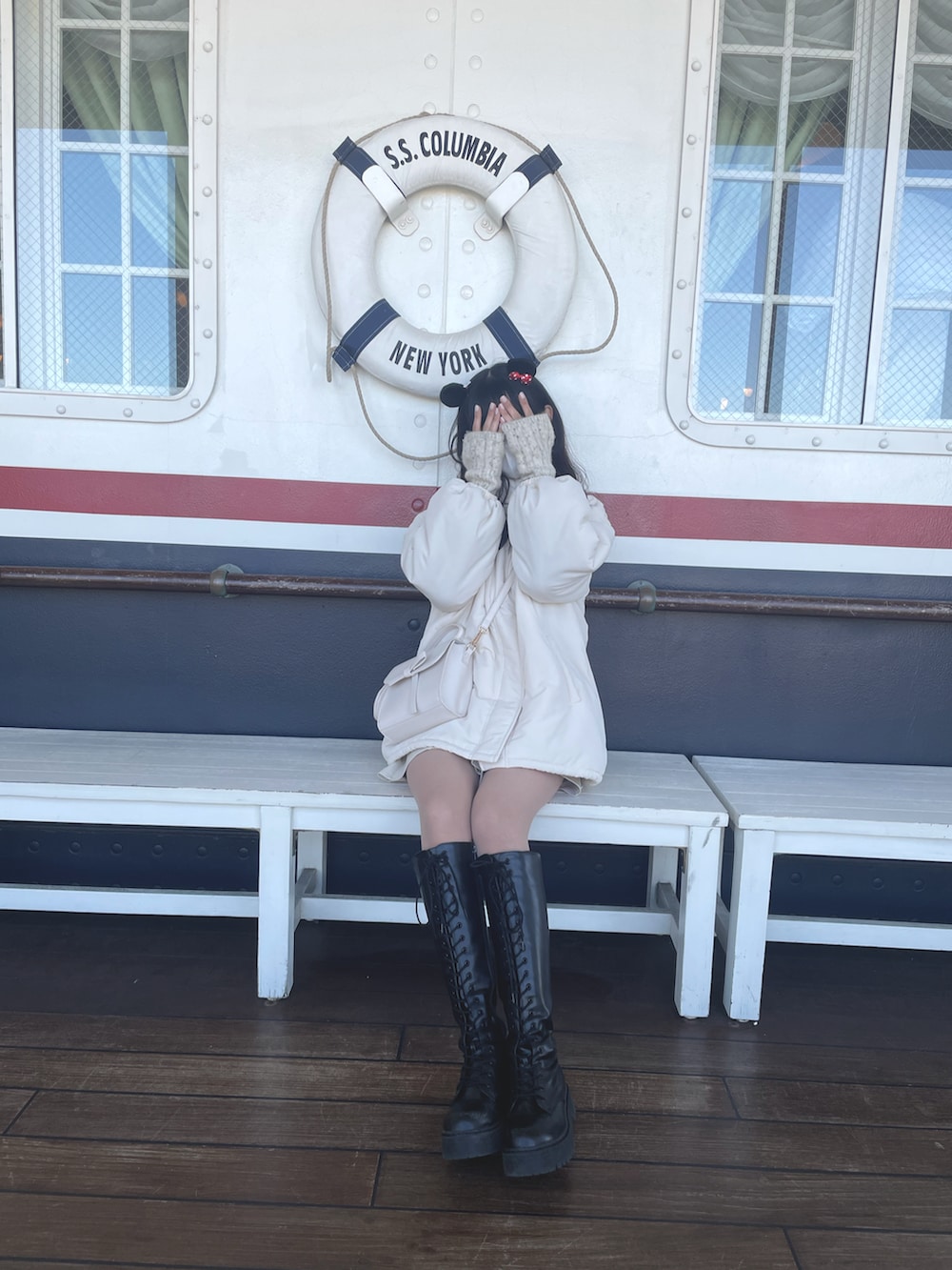 ホワイト系のブルゾン、ベージュ系のニット/セーター、ブラック系のブーツを着用したレディースの春コーディネートの2枚目の写真