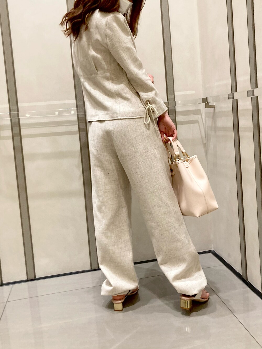 ホワイト系のサンダル、ベージュ系のパンツ、ベージュ系のジャケット/アウターを着用したレディースの春コーディネートの3枚目の写真