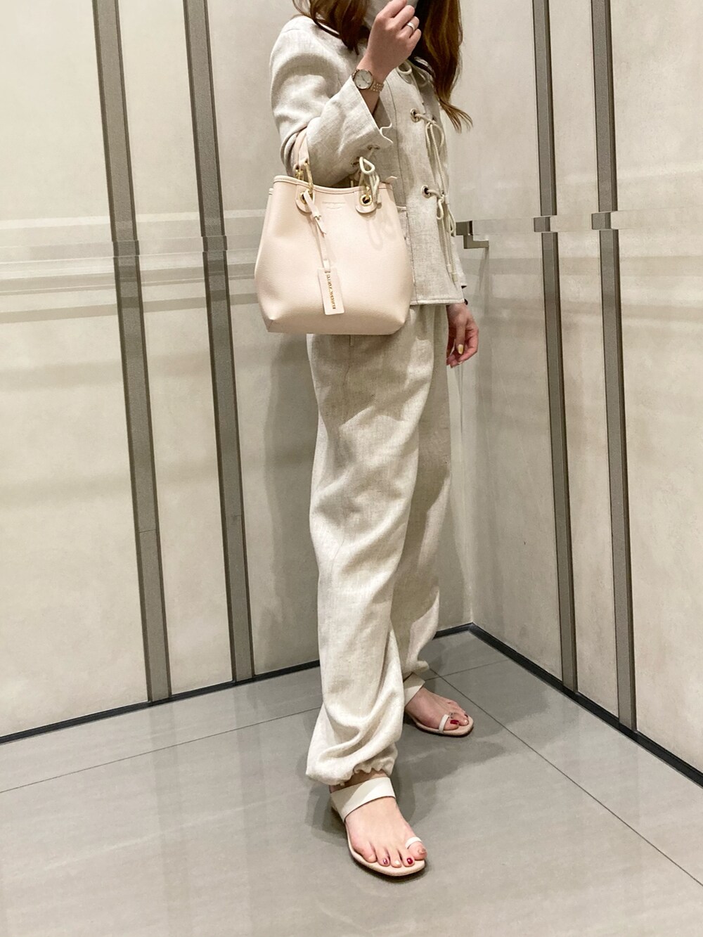 ホワイト系のサンダル、ベージュ系のパンツ、ベージュ系のジャケット/アウターを着用したレディースの春コーディネートの2枚目の写真