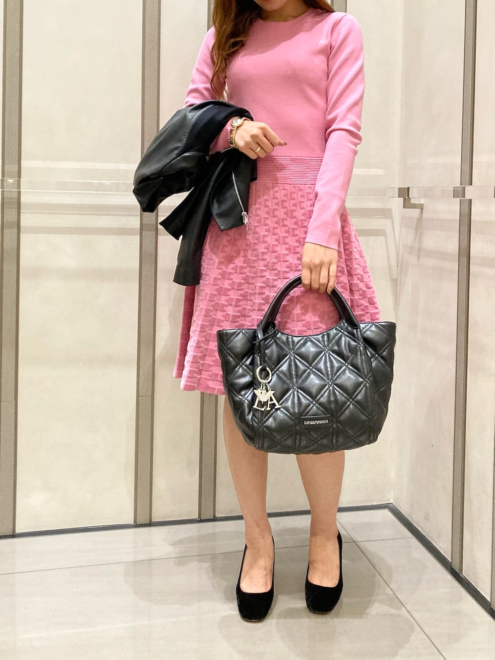 ブラック系のライダースジャケット、ピンク系のワンピース/ドレス、ブラック系のシューズを着用したレディースの秋コーディネートの3枚目の写真