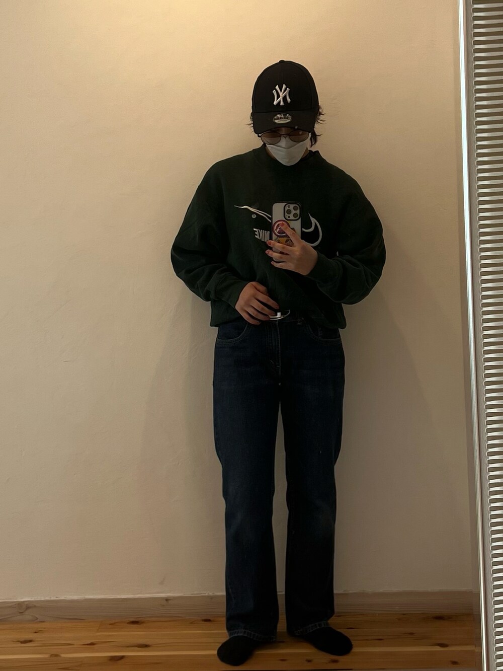 ブルー系のデニムパンツ、グリーン系のスウェット、ブラウン系のジャケット/アウターを着用したレディースの秋コーディネートの2枚目の写真