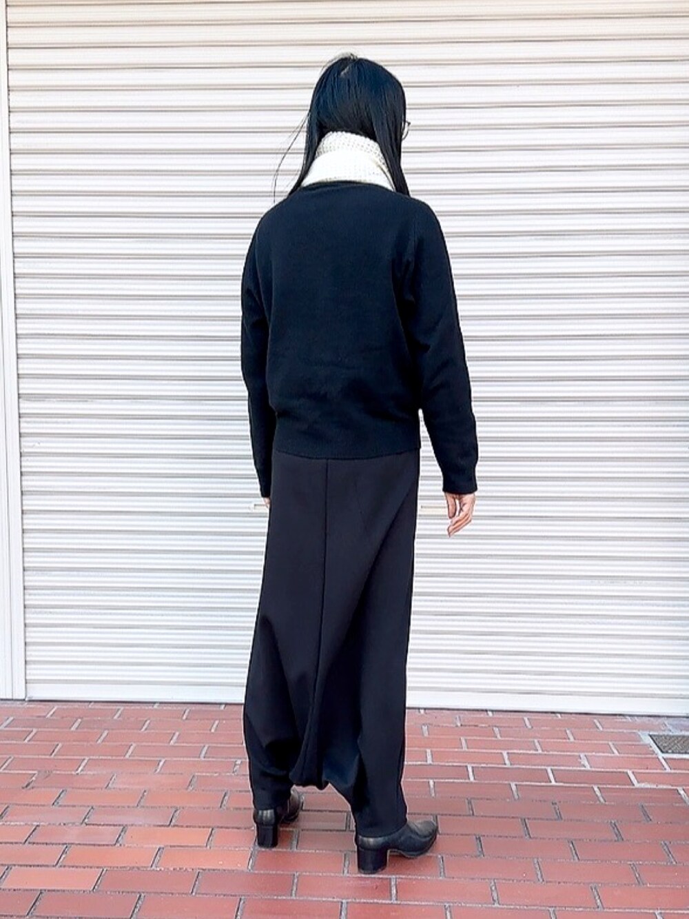 ブラック系のニット/セーター、ブラック系のその他パンツ、ブラック系のブーツを着用したメンズの春コーディネートの2枚目の写真