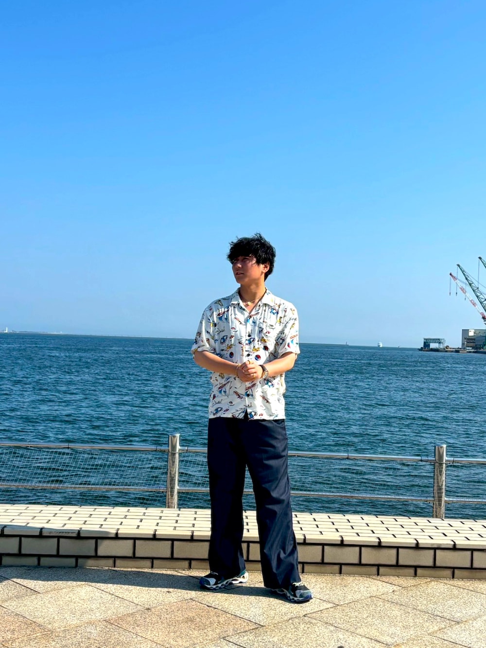 ホワイト系のシャツ/ブラウス、ブルー系のスラックス、グリーン系のスニーカーを着用したメンズの夏コーディネートの2枚目の写真