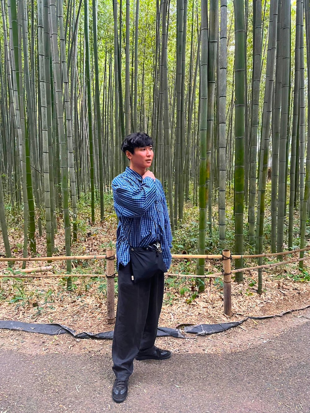 ブラック系のスニーカー、ブラック系のパンツ、ブラック系のショルダーバッグを着用したメンズの秋コーディネートの2枚目の写真