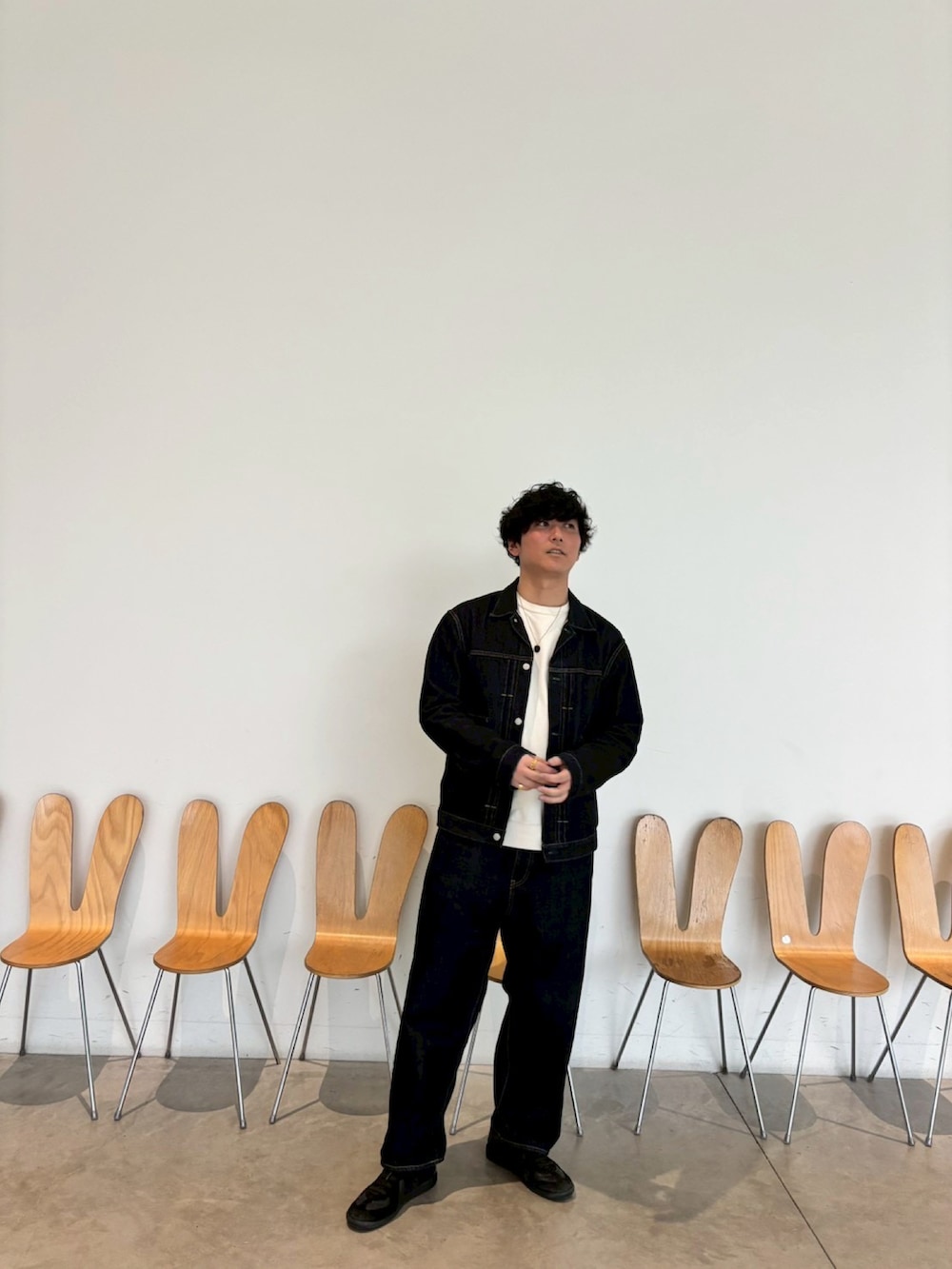 ブルー系のデニムジャケット、ブルー系のデニムパンツ、ブラック系のスニーカーを着用したメンズの夏コーディネートの2枚目の写真