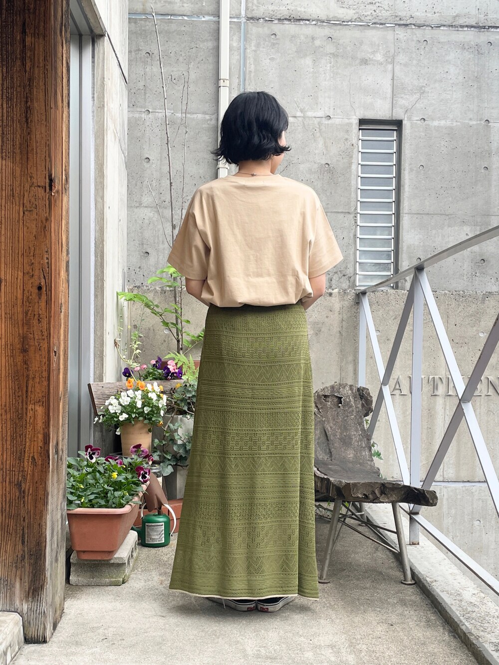 ベージュ系のTシャツ/カットソー、グリーン系のスカートを着用したレディースの春コーディネートの2枚目の写真