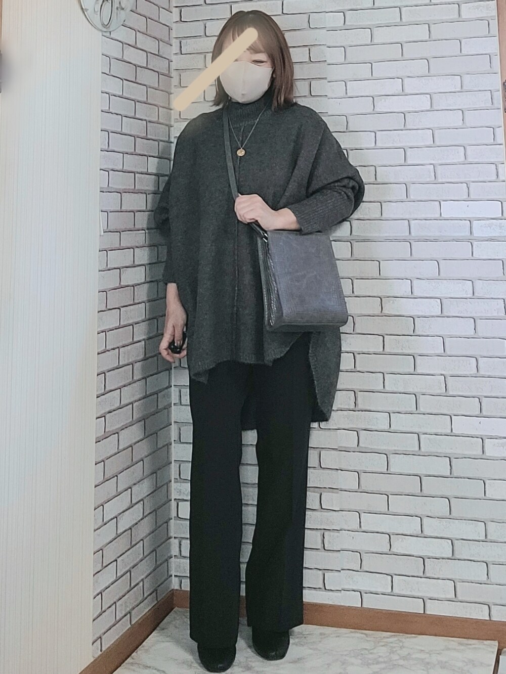 ベージュ系のノーカラーコート、ブラック系のニット/セーター、ブラック系のその他パンツを着用したレディースの秋コーディネートの2枚目の写真