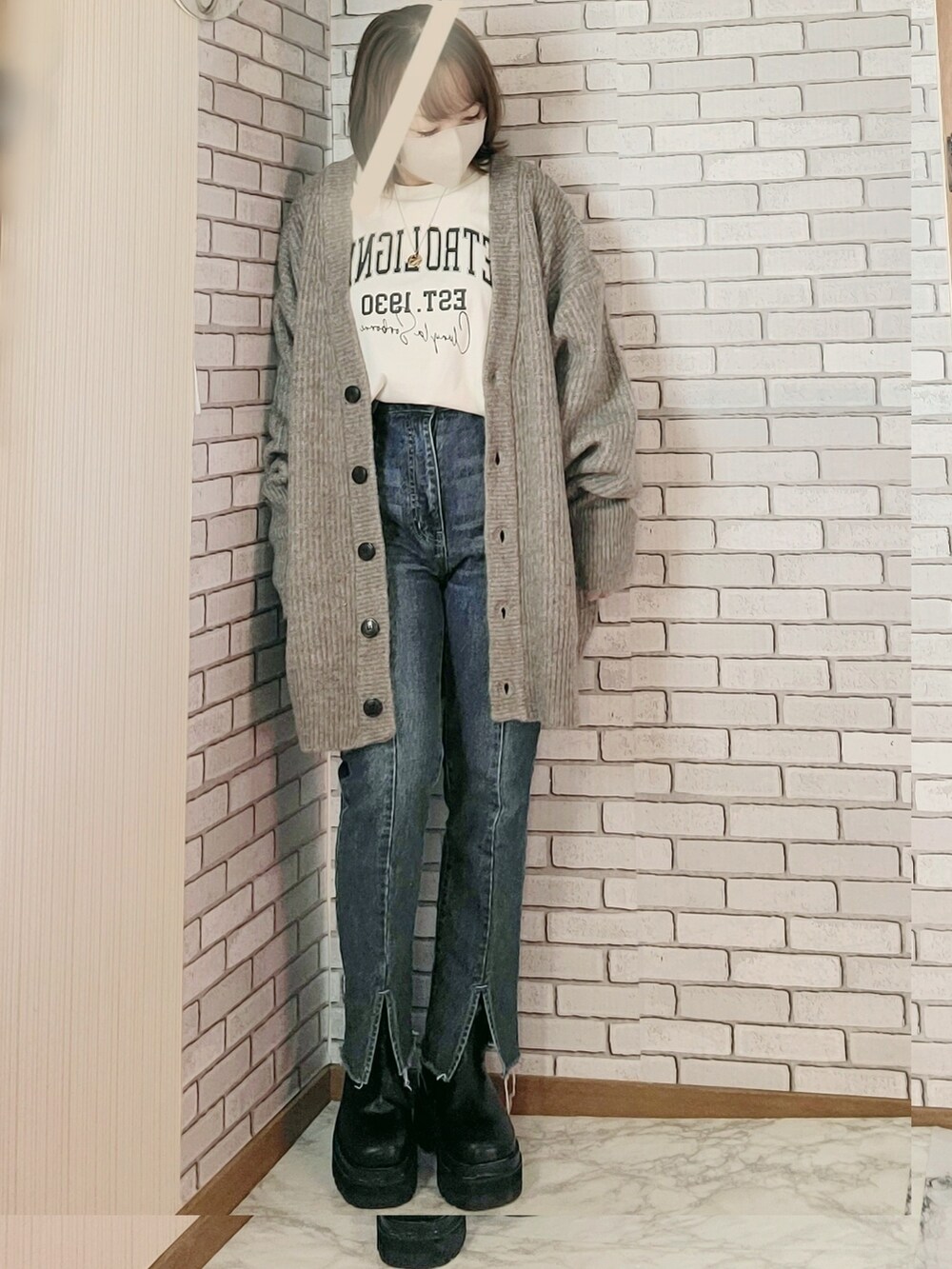 ブラック系のノーカラーコート、グレー系のカーディガン/ボレロ、ホワイト系のTシャツ/カットソーを着用したレディースの冬コーディネートの2枚目の写真