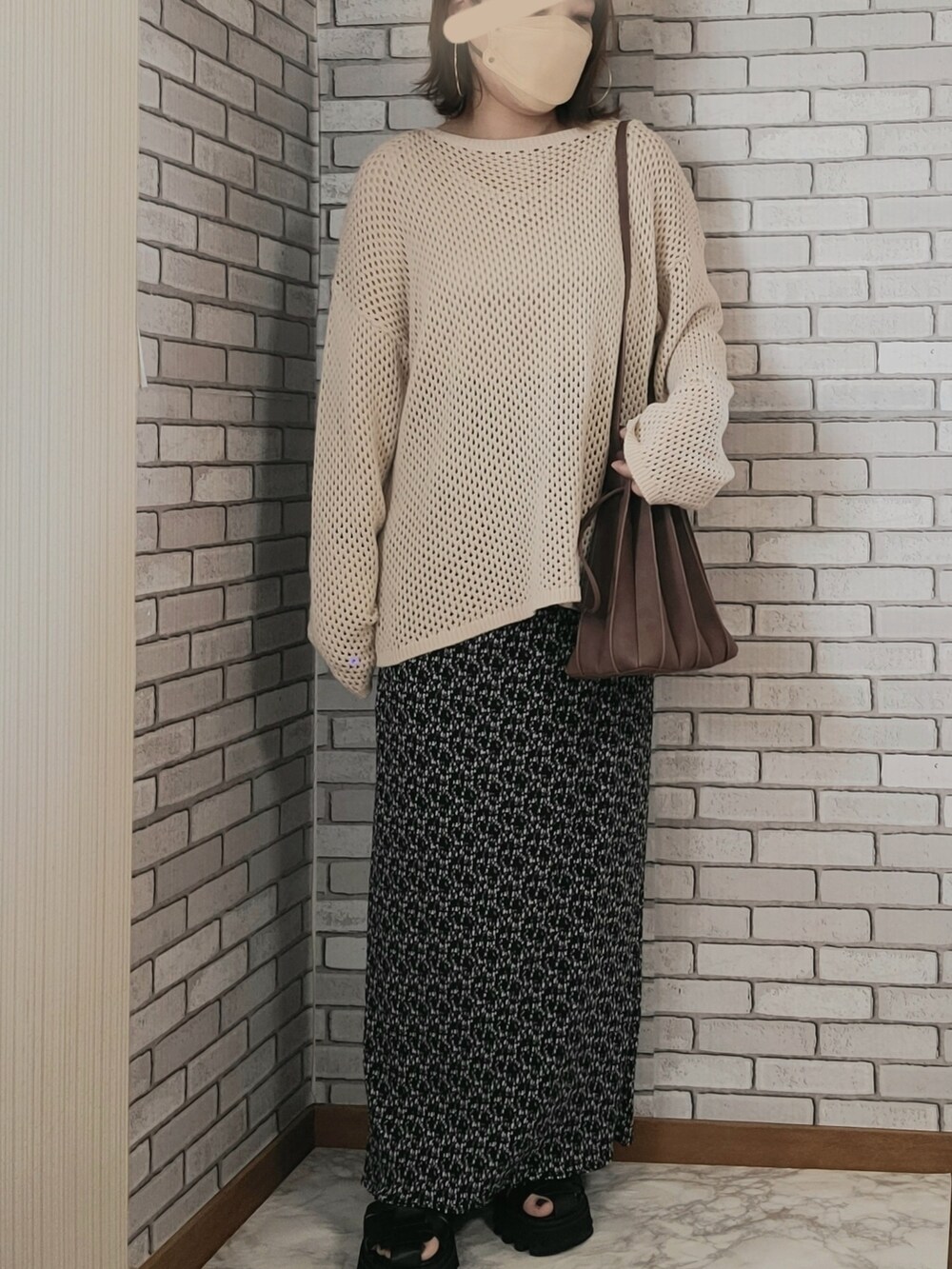 ベージュ系のニット/セーター、グリーン系のミリタリージャケット、ブラック系のスカートを着用したレディースの秋コーディネートの2枚目の写真