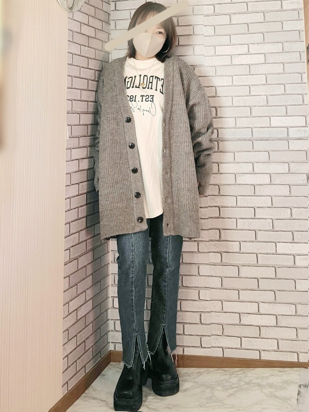 ブラック系のノーカラーコート、グレー系のカーディガン/ボレロ、ホワイト系のTシャツ/カットソーを着用したレディースの冬コーディネートの3枚目の写真