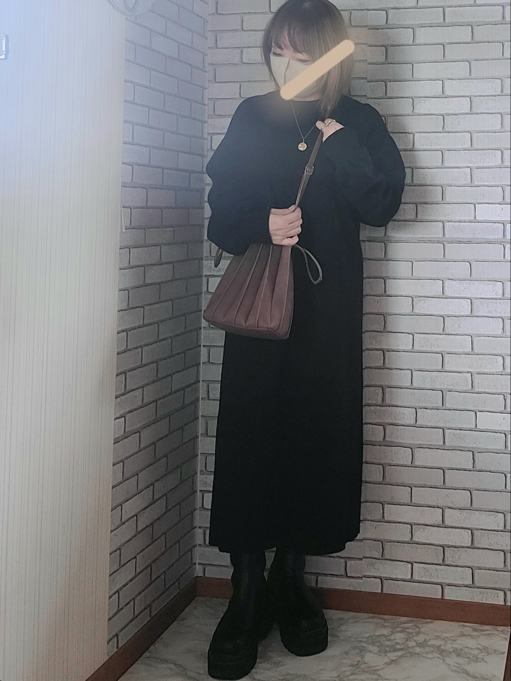 グリーン系のMA-1、ブラック系のワンピース、ブラック系のブーツを着用したレディースの秋コーディネートの2枚目の写真