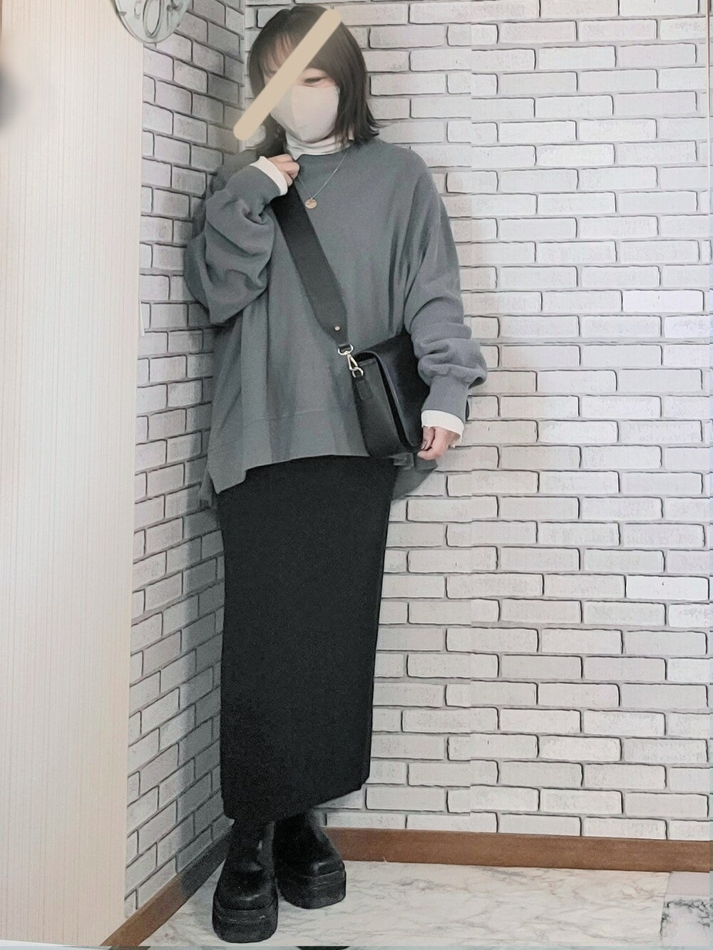 ブラック系のムートンコート、グレー系のスウェット、ホワイト系のTシャツ/カットソーを着用したレディースの冬コーディネートの2枚目の写真