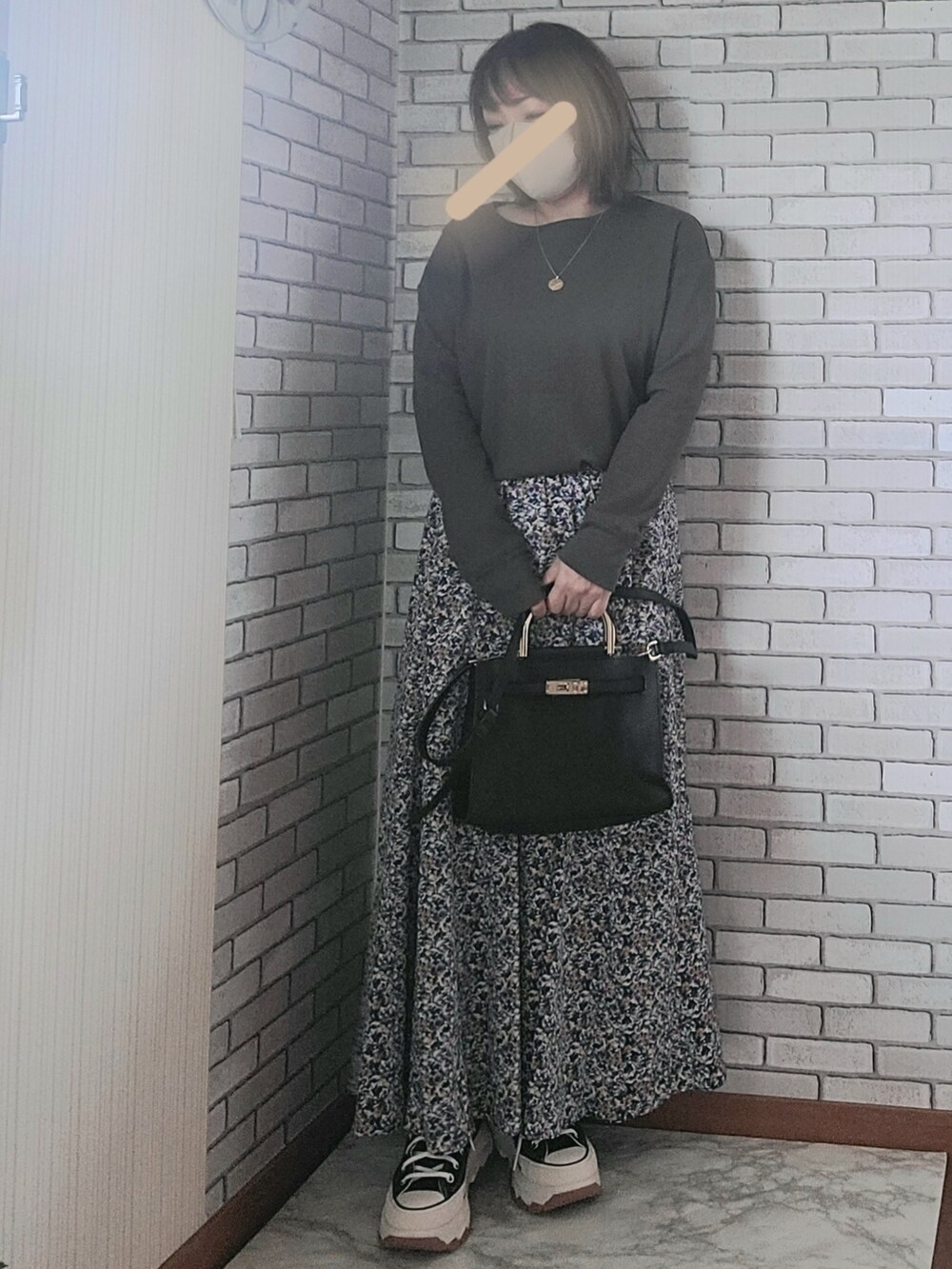 ベージュ系のカーディガン/ボレロ、グレー系のTシャツ/カットソー、ブルー系のスカートを着用したレディースの秋コーディネートの2枚目の写真