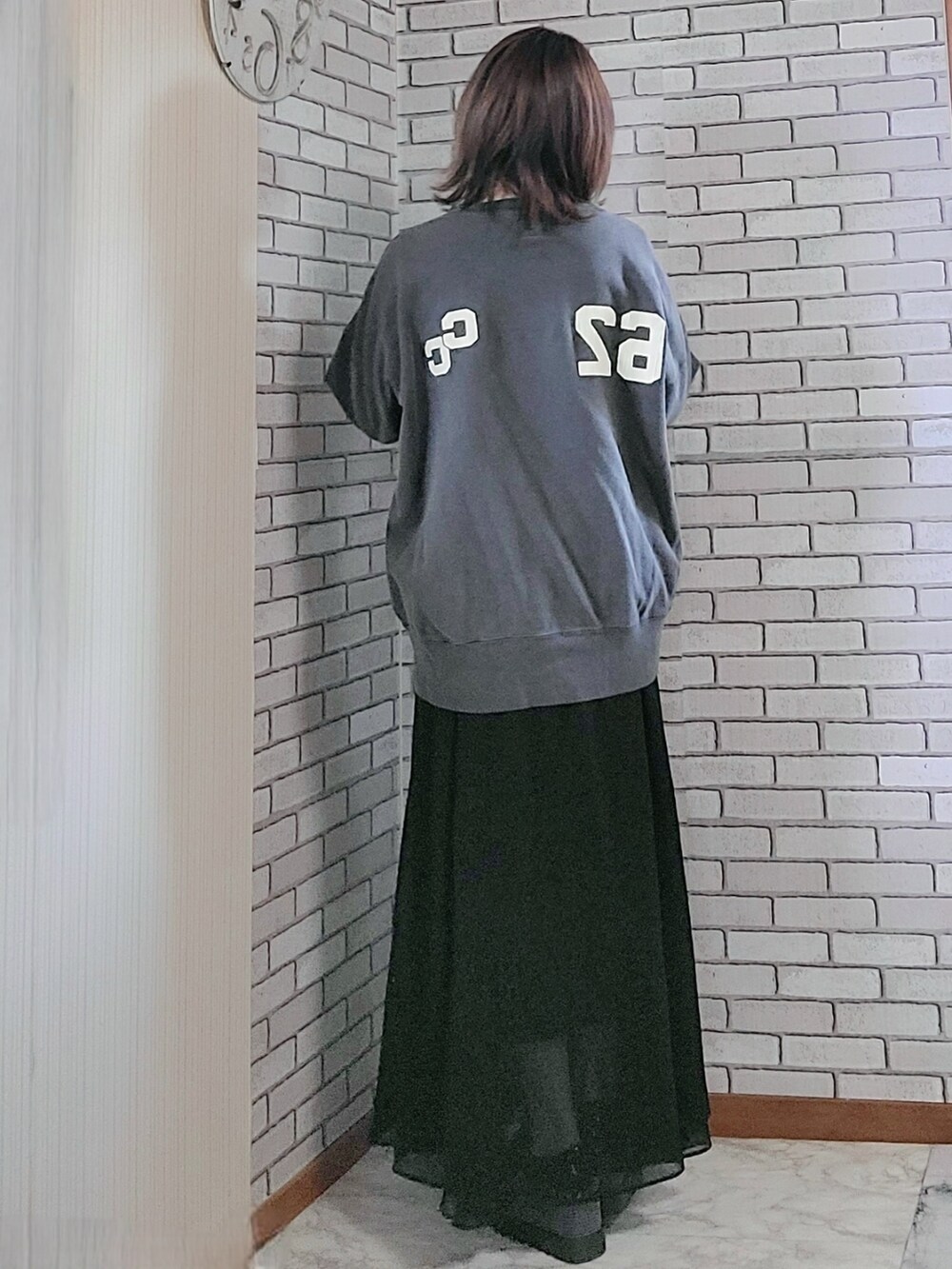 グリーン系のMA-1、ブラック系のスウェット、ブラック系のスカートを着用したレディースの春コーディネートの3枚目の写真